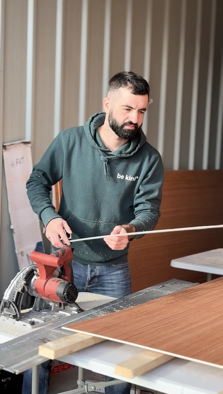 Prise de mesure sur un panneau avant la coupe, dans notre atelier