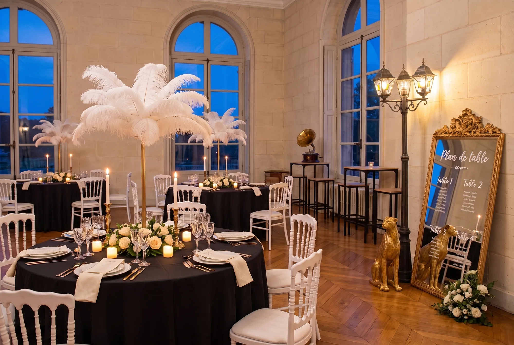 Dîner de mariage noir et or dans une salle de château : tables rondes nappées de noir, chaises blanches, centres de table en plumes d'autruche, chandeliers dorés, miroir doré en plan de table, lampadaire parisien et statue de guépard dorée