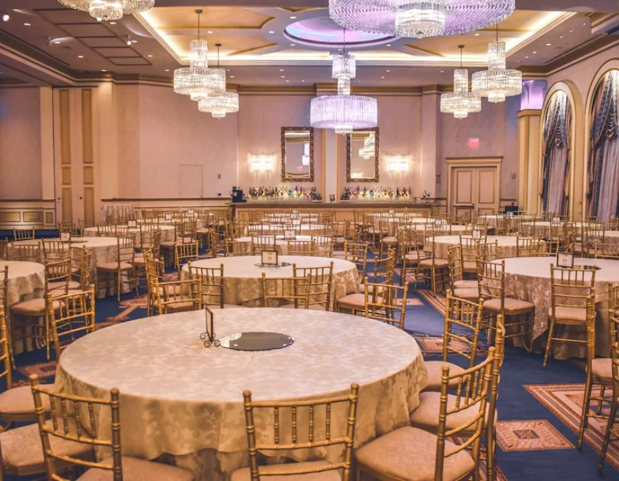 Salle de réception dressée : tables rondes et chaises dorées