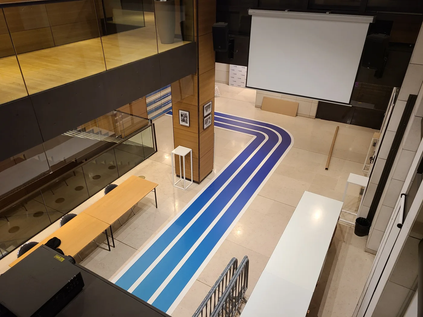 Parcours imprimé traversant l'espace d'accueil jusqu'à la salle de conférence