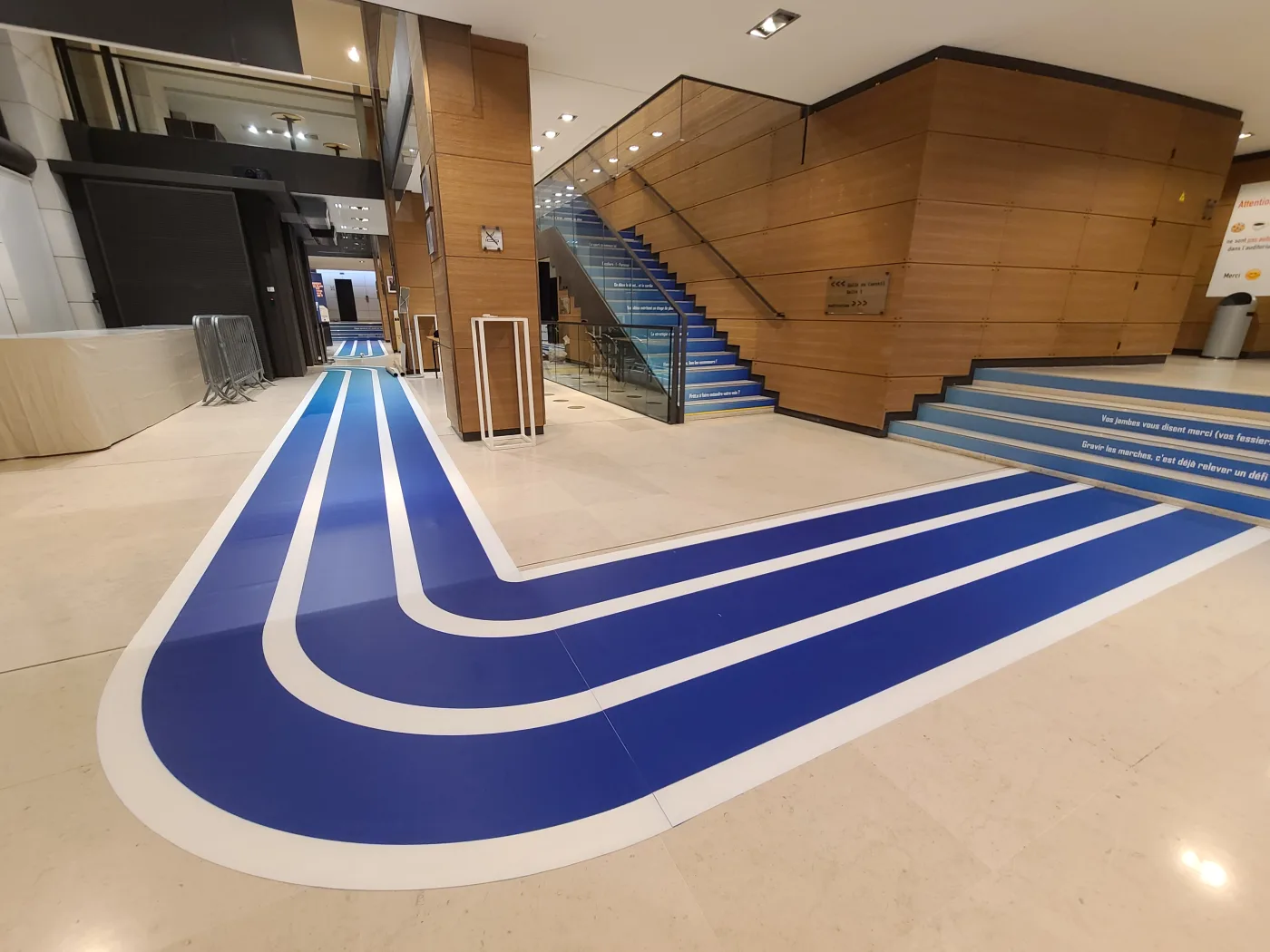 Grande courbe bleue imprimée au sol du hall du siège du MEDEF, façon piste d'athlétisme