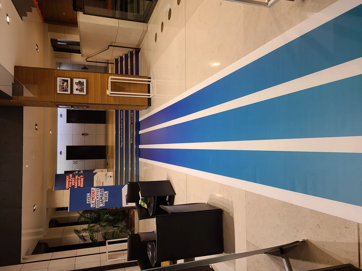 Visuel mural en rayons bleus posé dans le hall, dans les couleurs du MEDEF