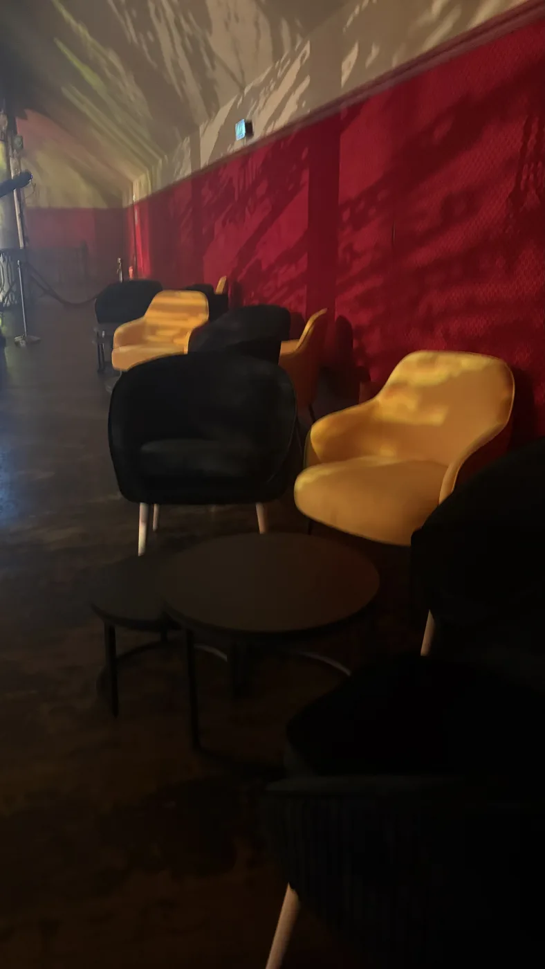 Fauteuils jaunes et noirs en velours et tables basses gigognes composant un espace lounge